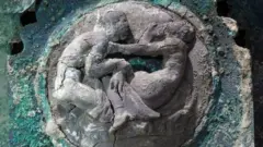 Close-up of design shows two figures