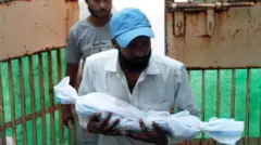 బిడ్డ శవాన్ని చేతుల్లో మోస్తున్న తండ్రి ఫోటో 
