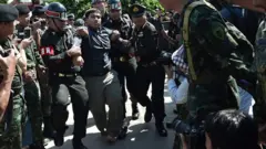 จ่านิวถูกควบคุมตัวที่สถานีรถไฟบ้านโป่ง จ.ราชบุรี ขณะจัดกิจกรรมนั่งรถไฟเดินทางไปตรวจสอบการทุจริตที่อุทยานราชภักดิ์ จ.ประจวบคีรีขันธ์ เมื่อวันที่ 7 ธ.ค. 2558