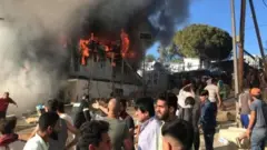 گفته می شود که آتش سوزی در یک کانتینر محل سکونت تعدادی پناهجو آغاز شد