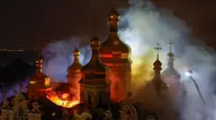 夜間にロシア正教会の建物の内部から炎が上がっているのを、見下ろす角度で撮影した写真。右端には、クレーンから放水する消防隊の姿が写っている