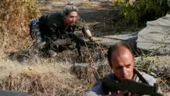 Voluntarios armenios sostienen armas en Yerevan