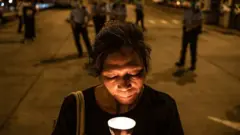 Pro democracy activist holds a candle
