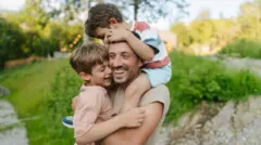 İki erkek çocuğu babalarına sarılmış