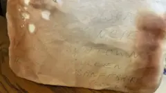 Pedaço de papel em que é possível ver algumas anotações como data e endereço de um local