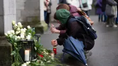 люди у стихийного мемориала жертвам пожара в Кран-Монтане