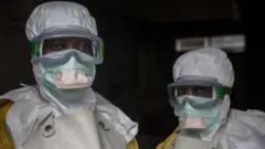 Le personnel médical vêtu d'équipement de protection avant d'entrer dans une zone d'isolement dans un centre de traitement d'Ebola à Goma.