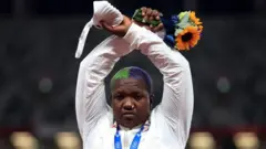 La médaillée d'argent au lancer du poids, l'Américaine Raven Saunders, fait des gestes sur le podium