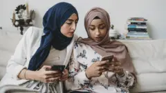 شاباتان تقرآن الأخبار من الهاتف الذكي
