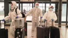 Three people at Gatwick Airport in the UK on 17 March 2020