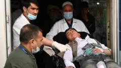 Medical staff move one of the wounded on a stretcher inside a hospital after blasts rocked a boys' school in a Hazara neighbourhood in Kabul on April 19, 2022.