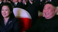 North Korean leader Kim Jong Un and his wife Ri Sol Ju watch a performance that commemorated the Day of the Shining Star