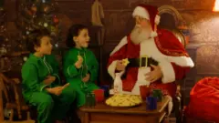 Papai Noel sentado com duas crianças