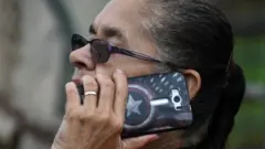 মোবাইল ফোনে কথা বলছেন এক নারী