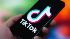 the TikTok logo is displayed on the screen of a smartphone