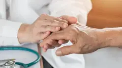 Manos siendo atendidas por un médico.