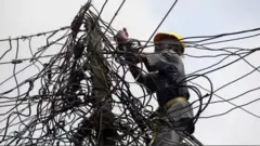 Osisẹ mọnamna kan n lọ waya ina lori opo