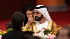 سيدة تهمس في إذن الشيخ محمد بن راشد في أحد المؤتمرات