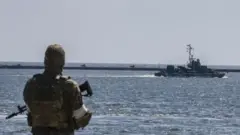 رجل ينظر إلى مركب في البحر