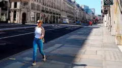 Woman in an otherwise deserted Regent St, London