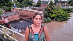 luana, moradora do Recife, em ponte acima da água, mostrando local do alagamento