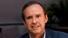 Close de Jorge Tuto Quiroga, com meio sorriso e vestindo azul.