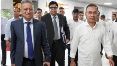 অর্থমন্ত্রী আমির খসরু মাহমুদ চৌধুরী প্রথা অনুযায়ী ব্রিফকেসে বাজেট বক্তৃতার কপি নিয়ে সংসদের অধিবেশন কক্ষে যাচ্ছেন, তার সঙ্গে প্রধানমন্ত্রী তারেক রহমান