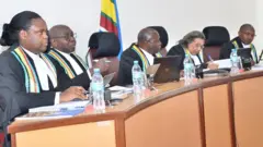 Abacamanza b’uru rukiko, kuva ibubafu uja iburyo, Anita Mugeni(Rwanda), Geoffrey Kiryabwire(Uganda), Nestor Kayobera(Burundi), Sauda Mjasiri(Tanzania), na Kathurima M'Inoti(Kenya)