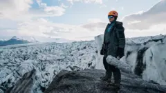 Vlasis con un micrófono en la mano en un glaciar