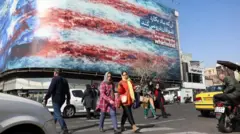 یک خیابان در ایران و مردم و خودروها در حال عبور و مرور