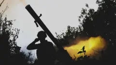 এক ইউক্রেনীয় সেনা গ্রেনেড লঞ্চার ব্যবহার করছেন।