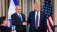 O primeiro-ministro de Israel, Benjamin Netanyahu, com sorriso no rosto, cumprimenta com aperto de mão o presidente dos EUA, Donald Trump, com um olhar sério em frente a repórteres na Casa Branca, após apresentação de plano de paz para Gaza. Atrás deles há bandeiras dos dois países.