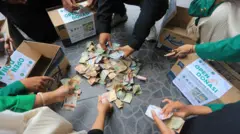 Sejumlah mahasiswa Universitas Sekolah Tinggi Agama Islam Negeri (STAIN) Teuku Dirundeng menghitung donasi untuk korban bencana banjir Aceh di Simpang Pelor, Meulaboh, Aceh Barat, Aceh, Rabu (10/12/2025). Penggalangan dana dan pembukaan posko donasi yang dilakukan mahasiswa tersebut sebagai bentuk kepedulian dan solidaritas untuk membantu meringankan beban korban bencana hidrometeorologi di sejumlah daerah Aceh. 