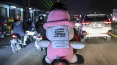 Pemudik bersepeda motor membonceng boneka saat melintas di jalur Pantura, jalan Raya Klari, Karawang, Jawa Barat, Rabu (19/04)