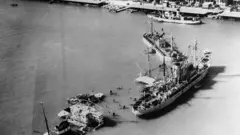 Vista aérea dos navios de bloqueio que foram afundados na entrada do canal de Suez em Port Said, no Egito. No canto direito, encontra-se um dos navios de salvamento em meio ao trabalho de liberação do canal