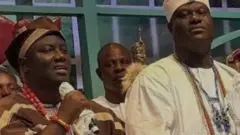 Aláàfin Abimbola Owoade wọ agbada àti Sokoto aláwọ̀ Kọfi àti Goolu, ó dé fìlà abeti ajá, ó fi ìlẹ̀kẹ̀ ńlá méjì sọrun, tó sì mú gbohùngbohùn tí wọn fi aṣọ funfun we lọ́wọ́. Ọọ̀ni Adeyeye Ogunwusi dúró sí ẹgbẹ́ Aláàfin, ó dé adé sórí, ó wọ agbada àti Sokoto aláwọ̀ miliki sọrun, O si fi ìlẹ̀kẹ̀ sọrun pẹlu 
