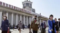 2020년 북한 주민들이 마스크를 착용하고 평양 기차역 앞을 지나가고 있다