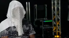 Man wey wear a mask and a hood