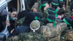 مسلحون من حماس يسلمون الرهينات الإسرائيليات الثلاث للجنة الدولية للصليب الأحمر كجزء من وقف إطلاق النار وصفقة التبادل بين حماس وإسرائيل، في مدينة غزة، 19 يناير/ كانون الثاني 2025.