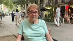 Senhora sentada em uma cadeira na rua em Barcelona, na Espanha