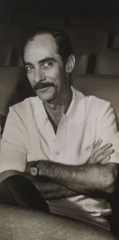 Foto em branco e preto de Dias Gomes, com braços cruzados, usando relógio e camisa branca