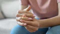 женщина снимает с пальца обручальное кольцо