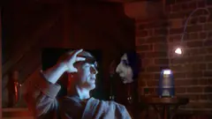 A man speaking to a floating holographic head - a section of the Tomorrow's World programme