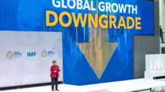 IMF總裁克里斯塔利娜·格奧爾基耶娃（Kristalina Georgieva）在華盛頓總部發表演說，背景電子幕牆展示著英文「全球增長降級」標題（9/4/2026）