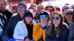 Pessoas com semblante sério na arquibancada após o acidente de Vonn.