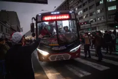 Ônibus manobrando e pessoas dando sinal