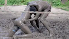 Two men covered in wrestle in a ring
