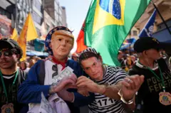 Protesto pela prisão do ex-presidente brasileiro Jair Bolsonaro e contra a decisão do presidente dos EUA, Donald Trump, de investigar o comércio digital e os serviços de pagamento eletrônico no Brasil, em uma zona comercial em São Paulo, Brasil, em 18 de julho.