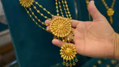 सुनका गहना समातिरहेको एक हात