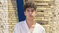 Sasan Azadvar, vestido con ropa de kárate, mira fijamente a la cámara.